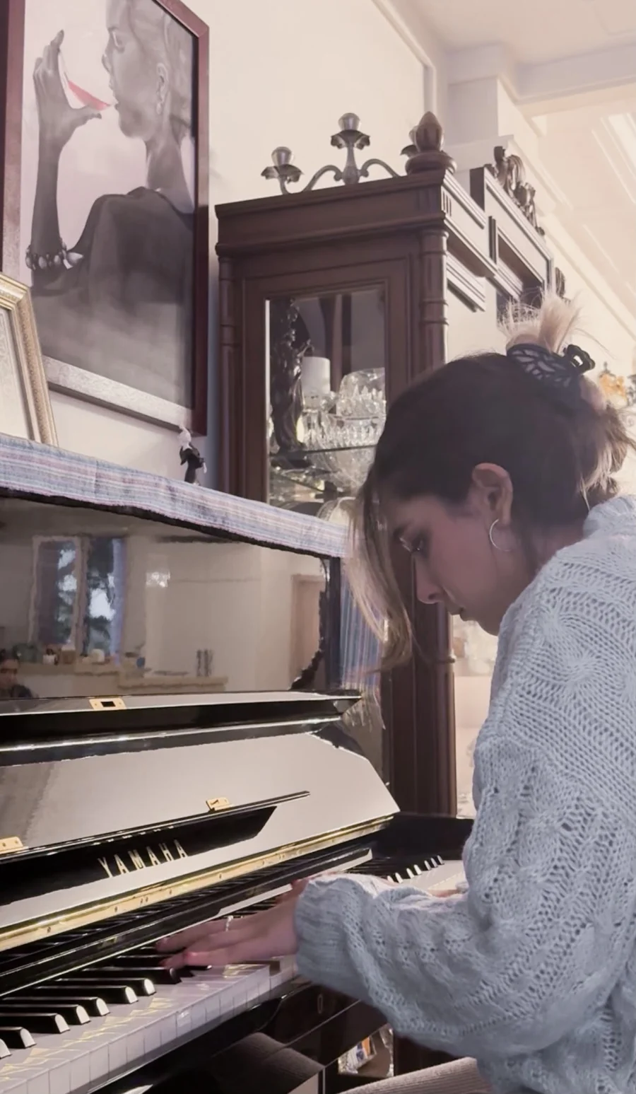 Nava playing a grand piano at home